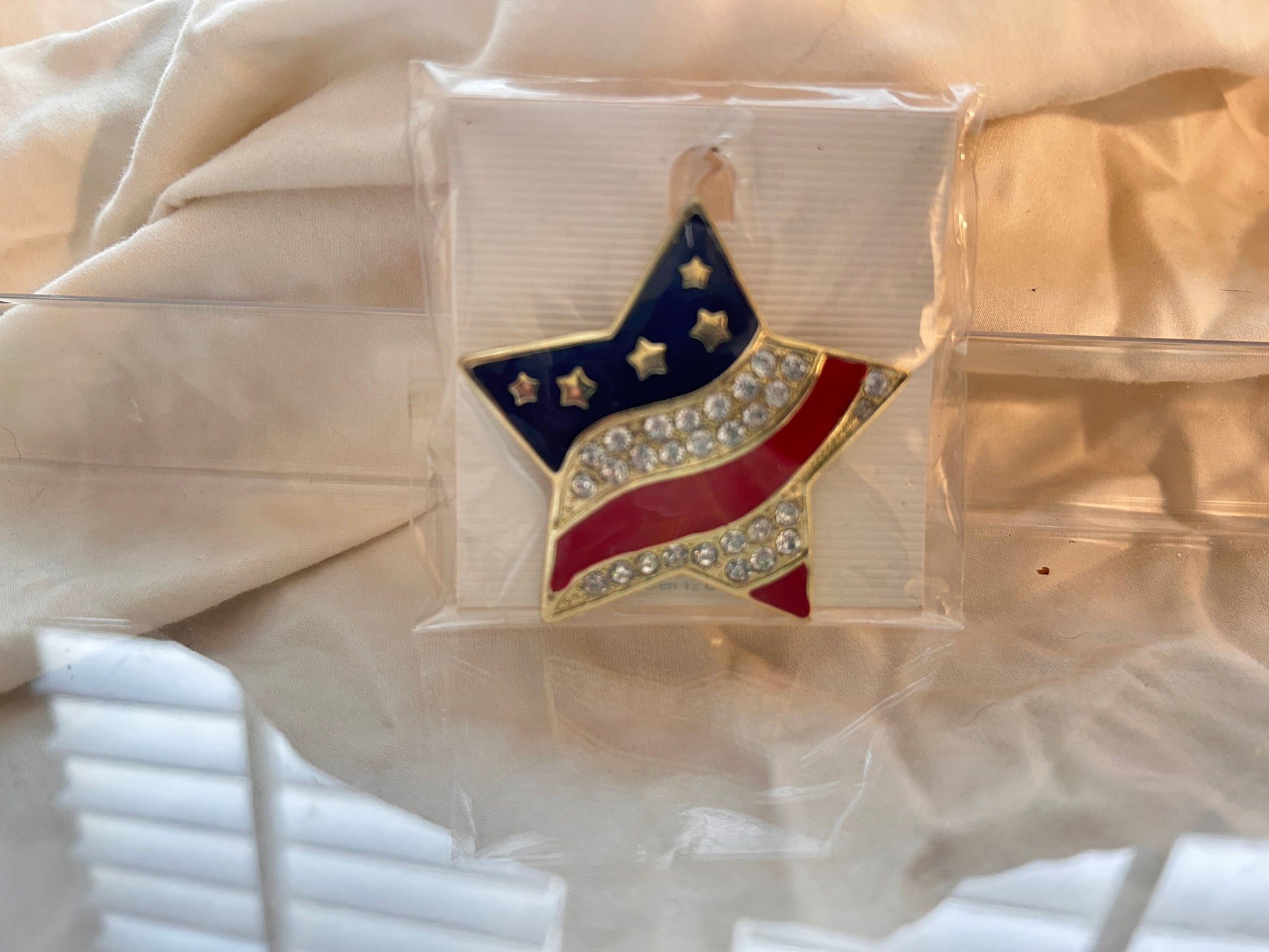 This brilliant pop of patriotism to your wardrobe. An Eye catching tribute to Old Glory. 
Good for lapels, dresses, denim jackets, hats and scarves. Dress it up or down.
Star shaped brooch featured a vibrant American flag design. Stripes encrusted with rows of shimmering clear rhinestones.  Perfect for Memorial Day, July 4, Labor Day or Veterans Day