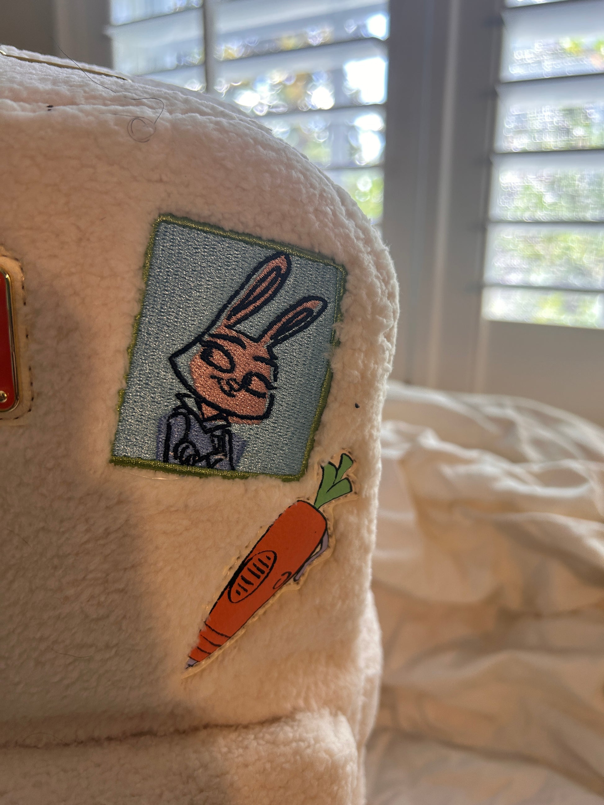 Whimsical Details: Adorned with iconic patches including Judy Hopps, a carrot, and the ZPD badge.Premium Quality: Crafted with high-quality craftsmanship, featuring a cloisonné Disney Parks x Loungefly metal plate and orange vegan leather trim.Functional Design: Includes a front zip pocket, two side slip pockets featuring sloths Flash and Priscilla, and adjustable padded shoulder straps.Compact & Durable: Measuring approximately 10.5" H x 9.5" W, it is made of durable polyurethane with a 100% polyester lini