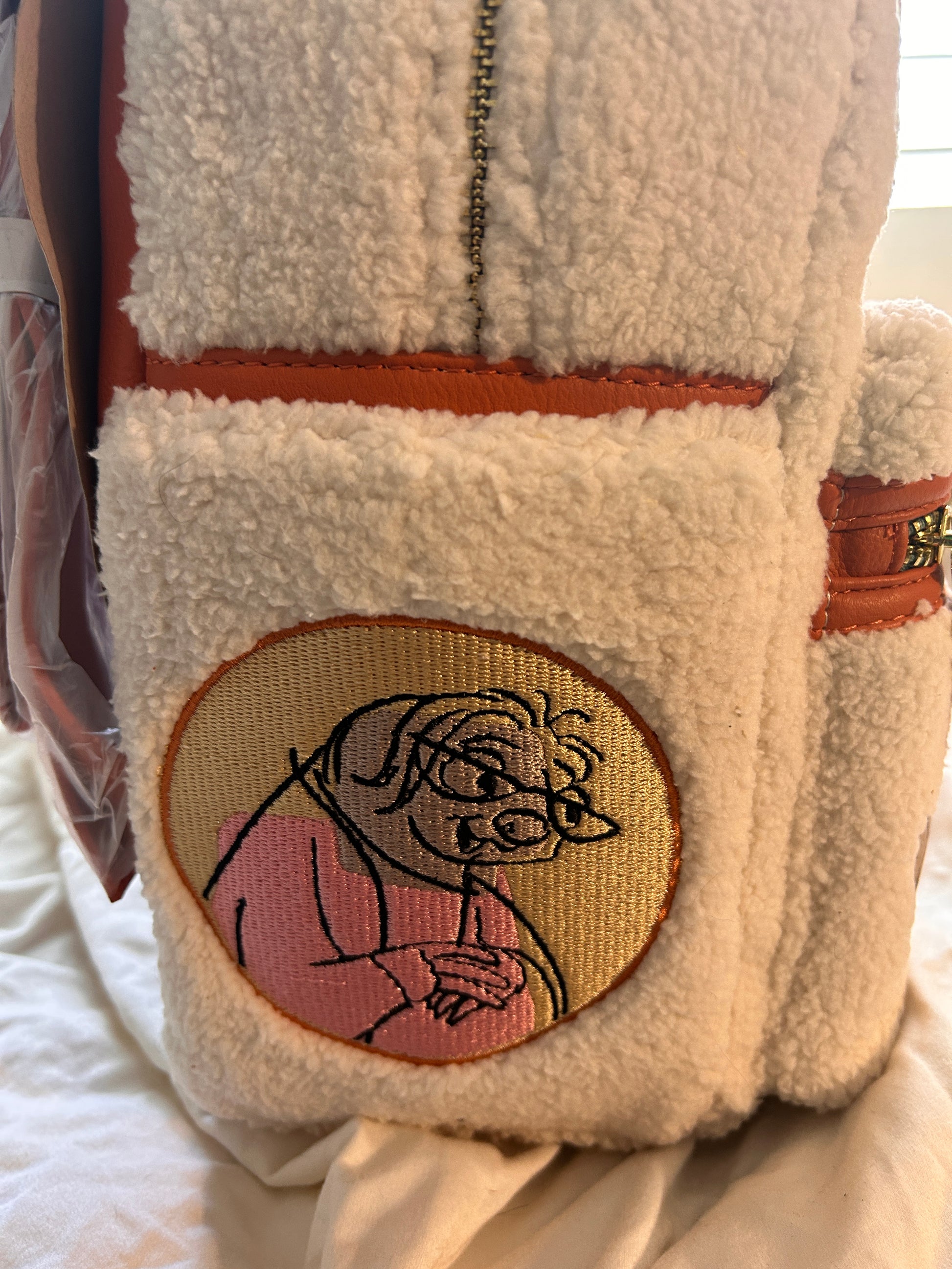 Whimsical Details: Adorned with iconic patches including Judy Hopps, a carrot, and the ZPD badge.Premium Quality: Crafted with high-quality craftsmanship, featuring a cloisonné Disney Parks x Loungefly metal plate and orange vegan leather trim.Functional Design: Includes a front zip pocket, two side slip pockets featuring sloths Flash and Priscilla, and adjustable padded shoulder straps.Compact & Durable: Measuring approximately 10.5" H x 9.5" W, it is made of durable polyurethane with a 100% polyester lini
