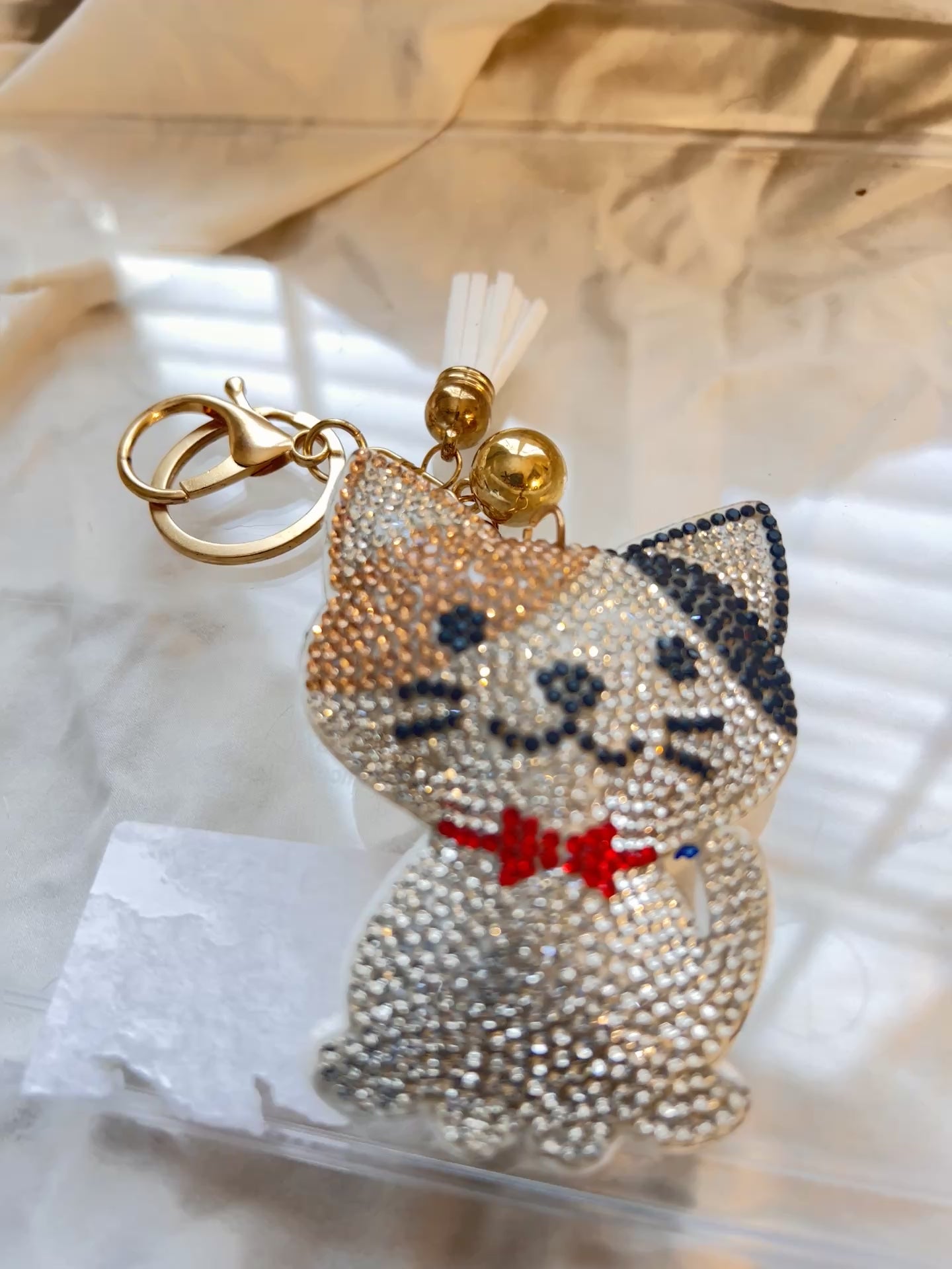 Cat keychain featuring a charming hand plushed texture&nbsp;

It wears a signature red bowtie and a premium gold clasp closure.&nbsp;

Whimsical accessory to elevate any handbag, backpack, or of course set of keys.