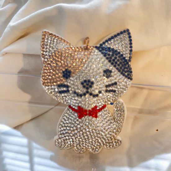 Cat keychain featuring a charming hand plushed texture&nbsp;

It wears a signature red bowtie and a premium gold clasp closure.&nbsp;

Whimsical accessory to elevate any handbag, backpack, or of course set of keys.